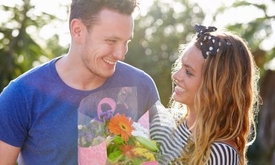 man geeft vrouw bloemen